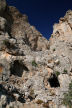 Kalymnos - detail of the crag behind Emborios showing the dressed stone construction of the Kastri and the cave openings and the enclave of towering cliff behind