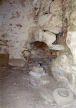 Nisyros - the uppermost part of the Siones complex is a single-room living space with original artifacts including the corner fireplace and pestles for grinding.