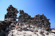 Nisyros - the remnants of the black volcanic rock constructions at the sulphur exporting 'harbour' of Agia Irini stand out starkly against the sky and in contrast to the white stockpiles