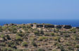 Nisyros - the massive structure of the ancient Paleokastro, now undergoing much needed restoration work, sits atop the  terraced fields which symbolise the agricultural wealth which underpinned this early, vigorous civilisation.  Even at this distance the individual building blocks can be clearly seen.