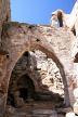 Nisyros - the inner courtyard of Siones looking through the bell arch of the chapel towards the steps up to the most recent living quarters and the entrance of the older underground rooms now used for agricultural storage 