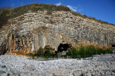 moss and algal growth caused by fresh water seepage from the cliff East of St Donat's - scale shown by the figure in the cave mouth