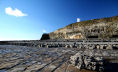 rocky foreshore looking West towards the low lighthouse at Nash Point