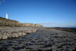 rocky foreshore looking East towards the tall lighthouse at Nash Point